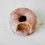 Featured image showing the finished cinnamon donuts with a bite missing ready to be enjoyed.