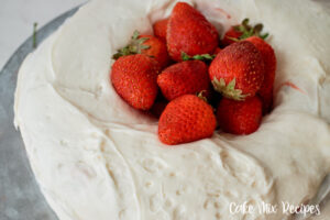 Featured image showing the full finished vanilla cake with strawberry filling ready to cut and serve.