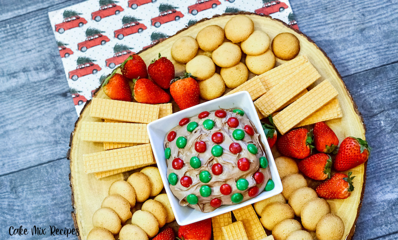 Finished dip surrounded by cookies, fruit, and crackers for dipping. 