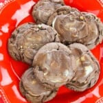 A red plate with a batch of chocolate mint cookies on top.