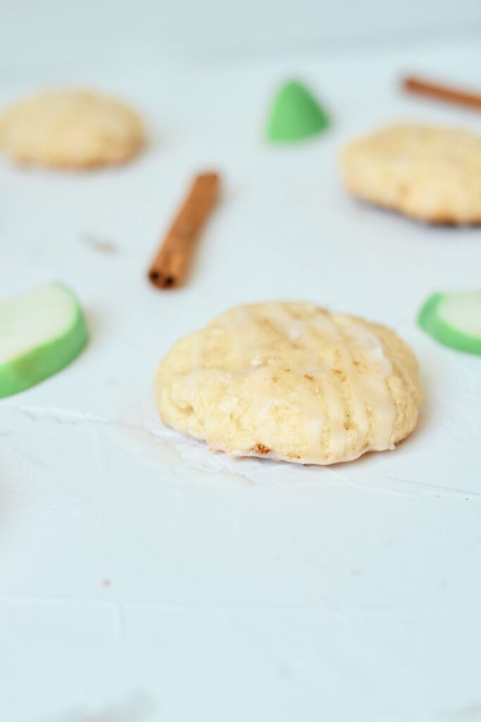 Apple Cinnamon Cookies with slices of green apple and cinnamon sticks in the background.