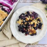 Featured image showing the finished blueberry dump cake served on a plate ready to eat.