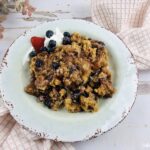 Featured image showing the finished berry dump cake cobbler on a plate ready to eat.