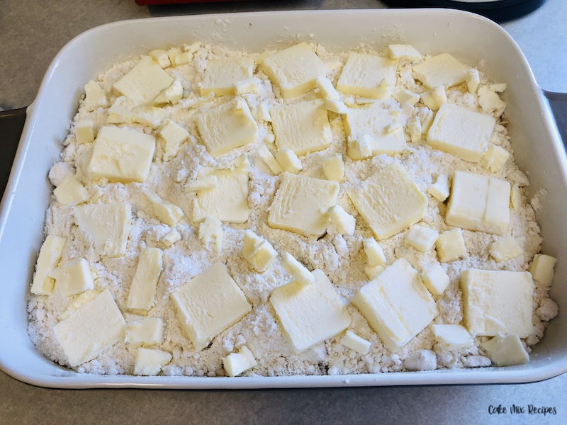 Butter sliced thin and layered over the entire top of the cake mix layer. 