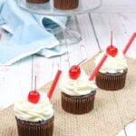 Three treats on a white tray with cherries and straws.