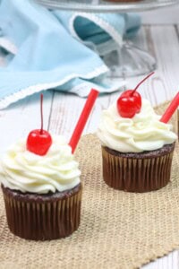 Two root beer float cupcakes on a tray.