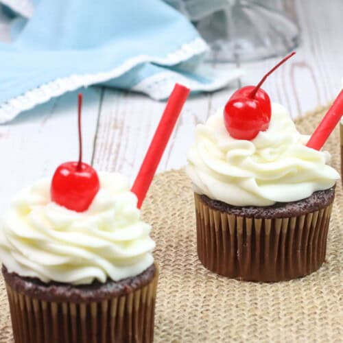 Two root beer float cupcakes on a tray.