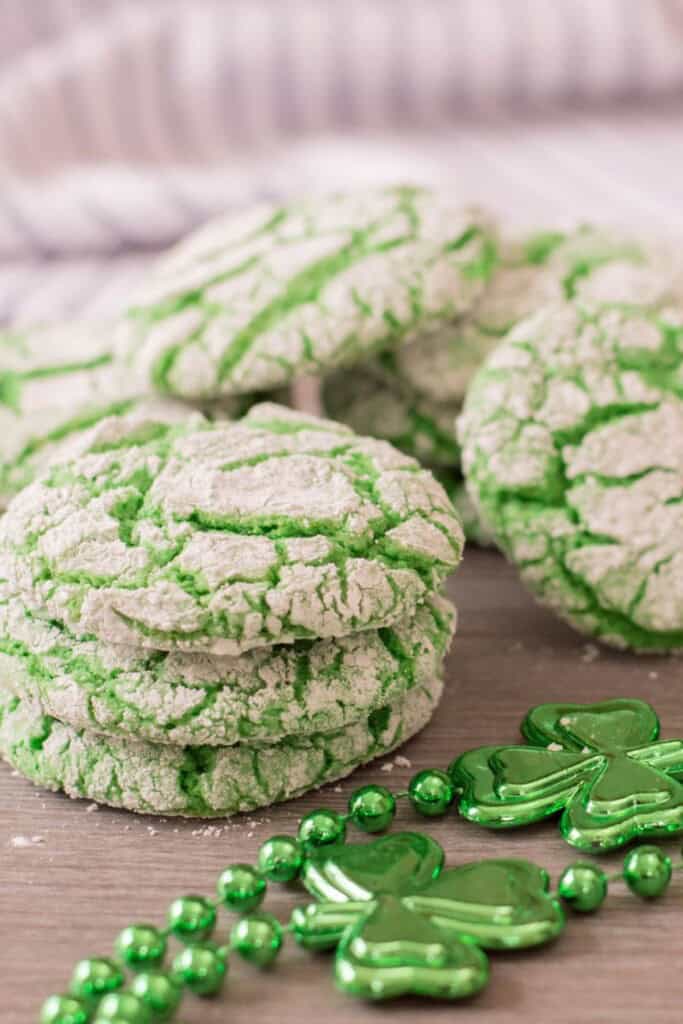 A stack of green vanilla crinkle cookies with green beads.