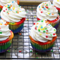 4 rainbow colorful cupcakes on a wire cooling rack