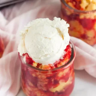 cherry dump cake in a mason jar with a scoop of ice cream