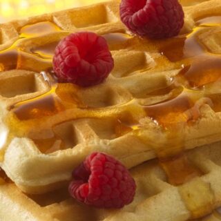 pancake mix waffles topped with maple syrup and raspberries