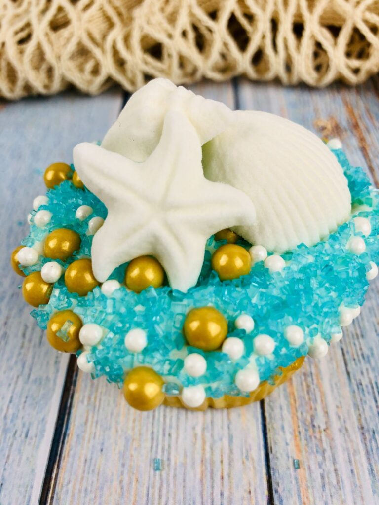 closeup of a beach cupcake on a wood table with a net behind it