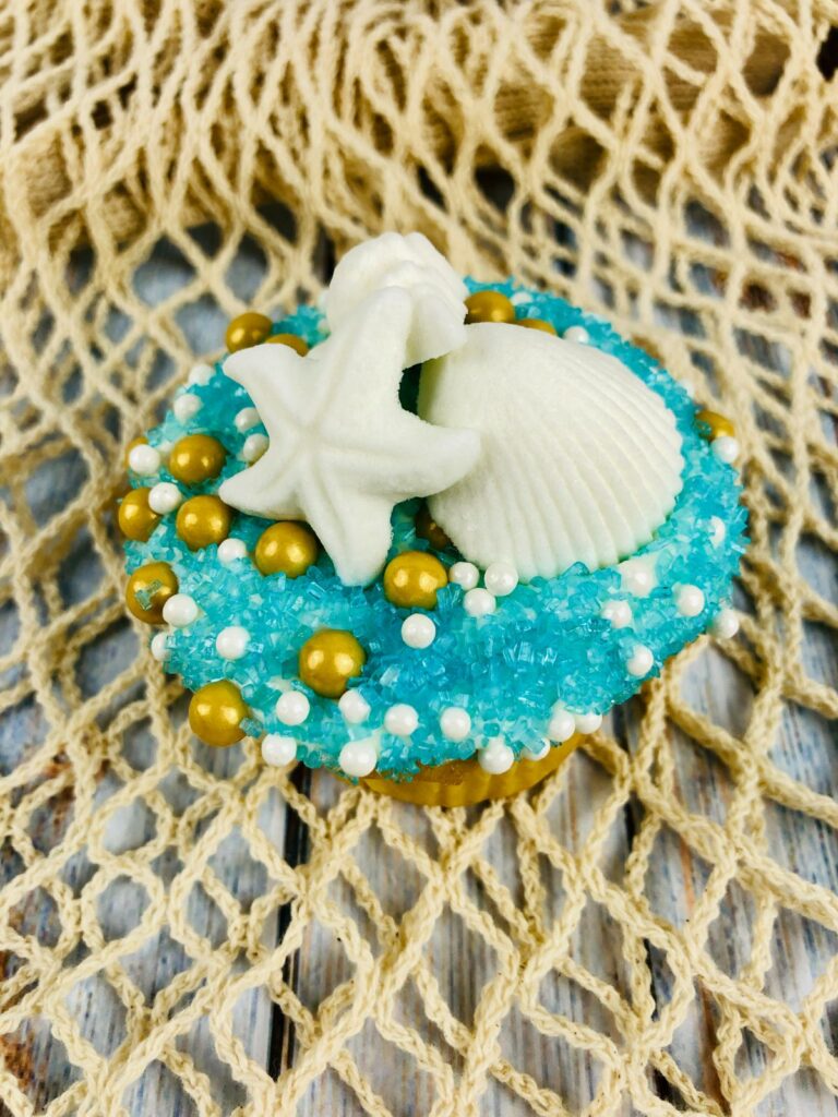 closeup of a beach cupcake on a net on a wood table