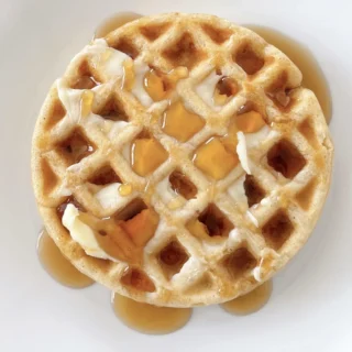 pancake mix waffle topped with maple syrup and served on a white plate