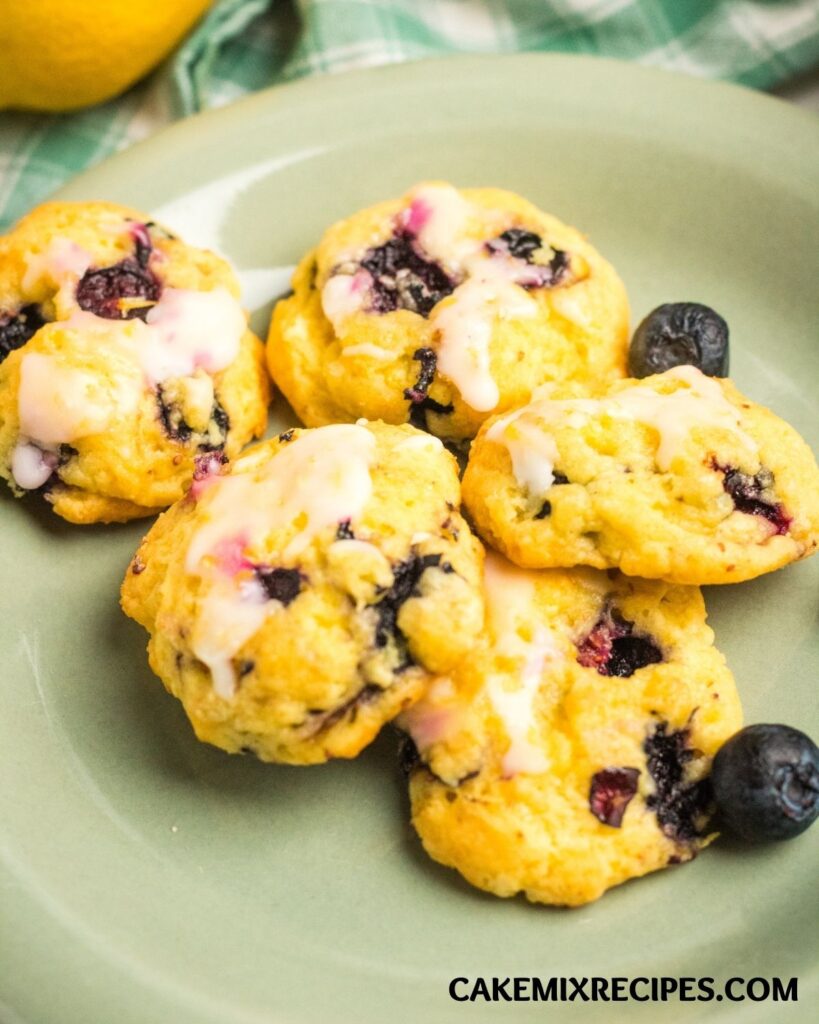 Lemon Blueberry Cookies on a green plate next to 2 blueberries
