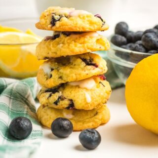 a stack of Lemon Blueberry Cookies next to a lemon and some blueberries