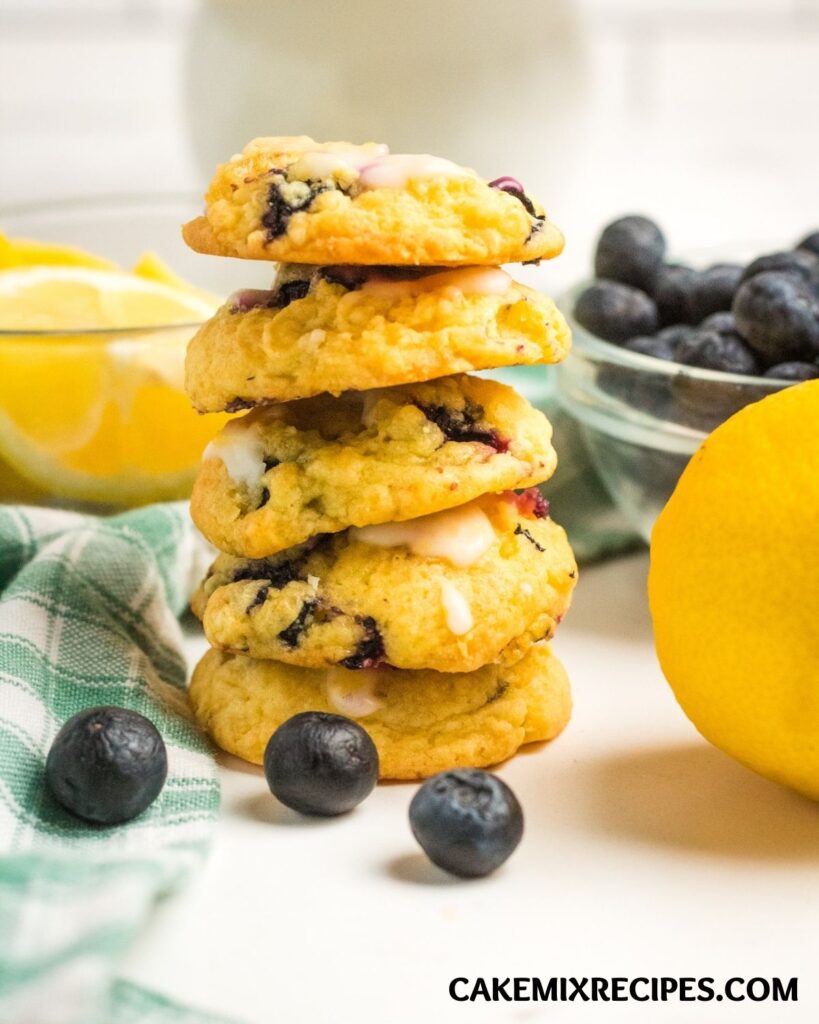 a stack of Lemon Blueberry Cookies next to a lemon and some blueberries
