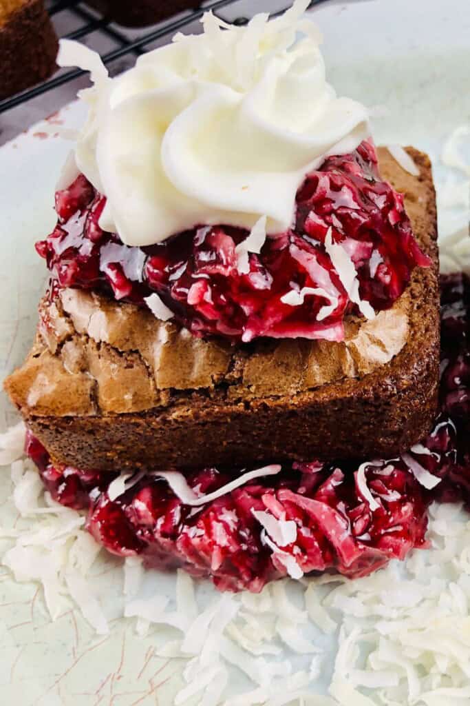 A brownie with raspberry sauce and whipped cream.