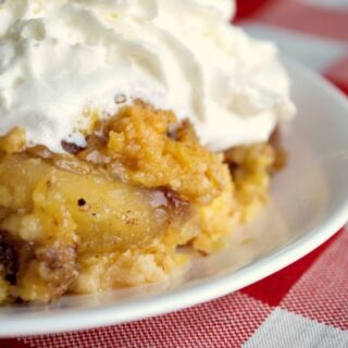 crockpot apple dump cake topped with whipped cream