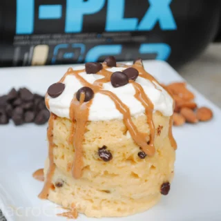 vanilla protein powder mug cake with chocolate chips and peanut butter drizzle