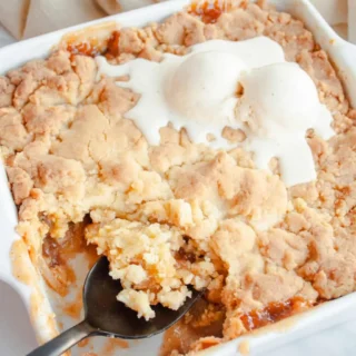 cake mix apple cobbler with vanilla ice cream in a serving dish