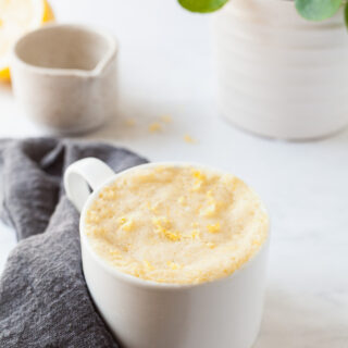 lemon cake in a mug topped with lemon zest