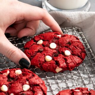 red velvet cake mix cookies on a cooling rack stuffed with white chocolate chips