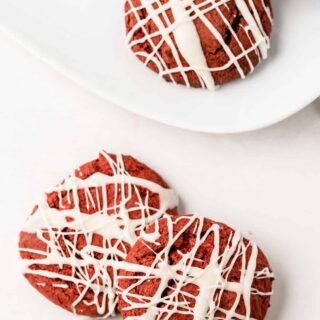 red velvet cake mix cookies topped with white chocolate drizzle