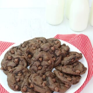 triple chocolate cake mix cookies on a plate with chocolate chips