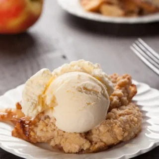 apple pie dump cake topped with vanilla ice cream and served with a fork