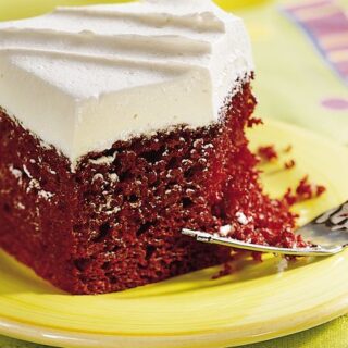 red velvet cake from mix served on a plate with frosting and a fork