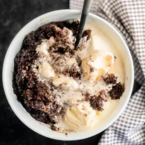 crockpot lava cake in a bowl with vanilla ice cream