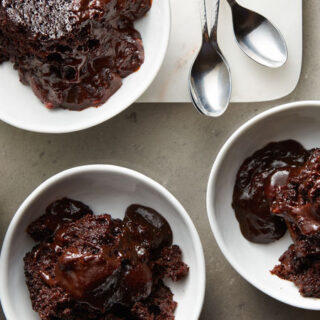 three portions of slow-cooker chocolate lava cake with a side of whipped topping