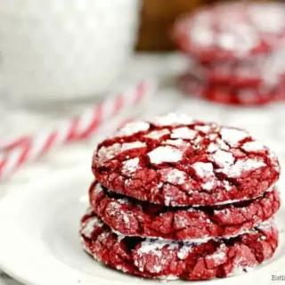 red velvet cake mix cookies stacked on a plate and topped with powdered sugar