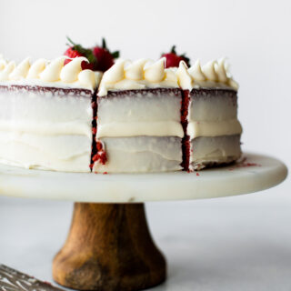 red velvet cake sliced into sections on a cake stand