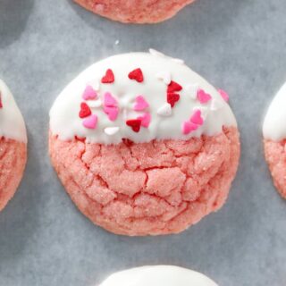 strawberry cake mix cookies dipped in white chocolate and topped with heart shaped sprinkles