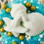 beach cupcakes with blue sand and colorful toppers.