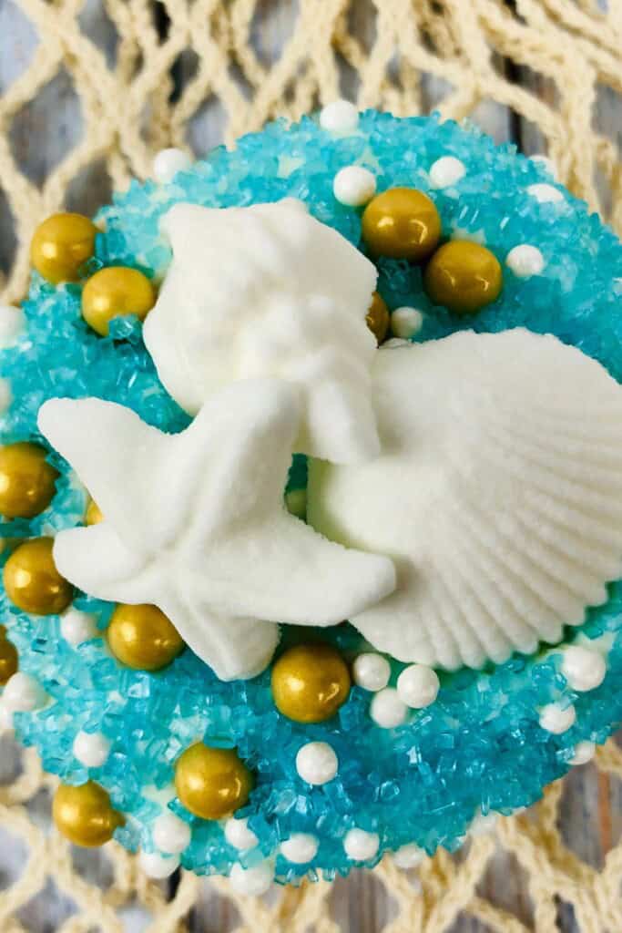 beach cupcakes with blue sand and colorful toppers.