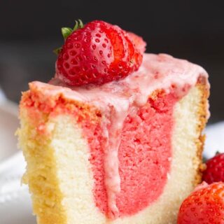 Strawberry and Cream Pound cake with pink icing and a fresh strawberry on top