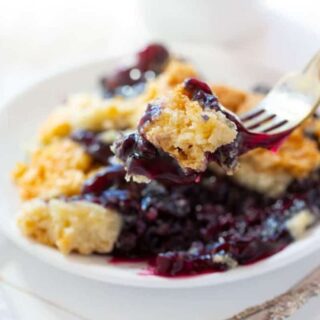 small plate of blueberry dump cake with a piece on a fork