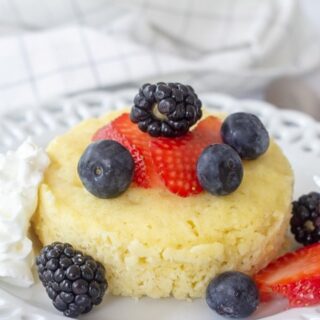 vanilla mug cake with fresh blueberries, strawberries and blackberries on top