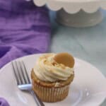 A treat on the plate with a vanilla wafer on top.