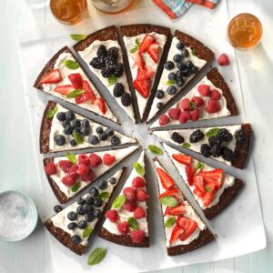 brownie pizza topped with icing and fresh berries