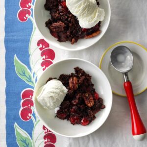 two bowls of chocolate-covered-cherry dump cake with a scoop of vanilla ice cream on top