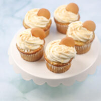 5 banana pudding cupcakes on a white cake stand