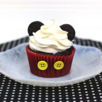 mickey mouse cupcake on a plate on a black mat