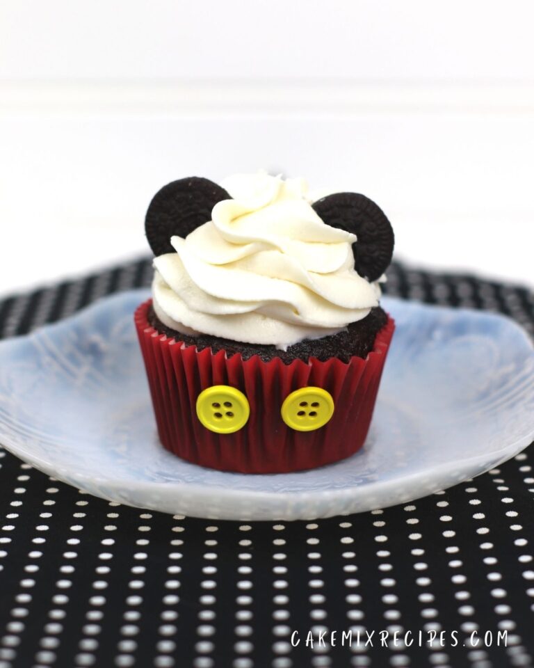 mickey mouse cupcake on a plate on a black mat