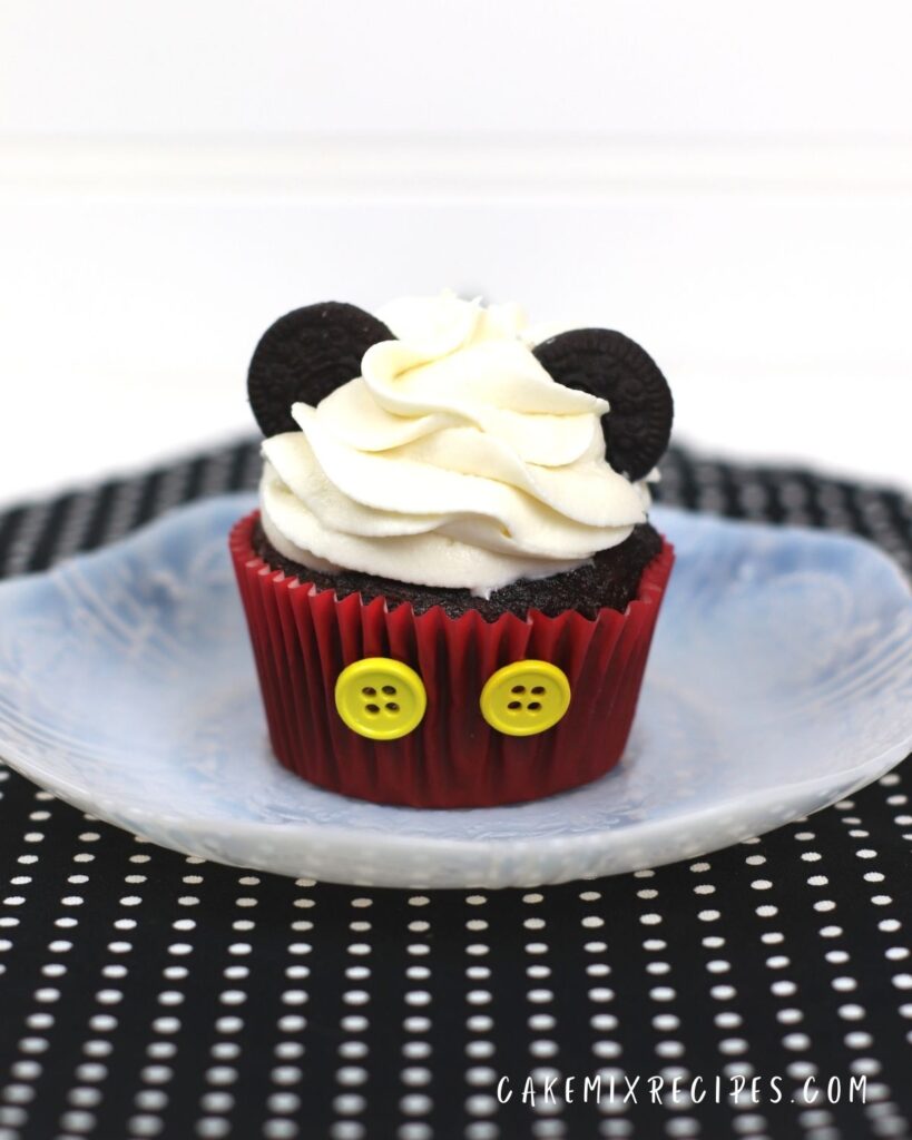 mickey mouse cupcake on a plate on a black and white polka dot cloth