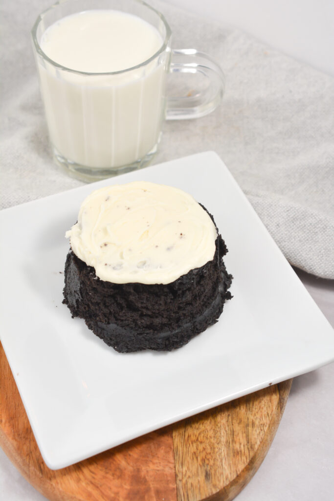 microwave oreo cake on a white plate with a glass of milk in the background