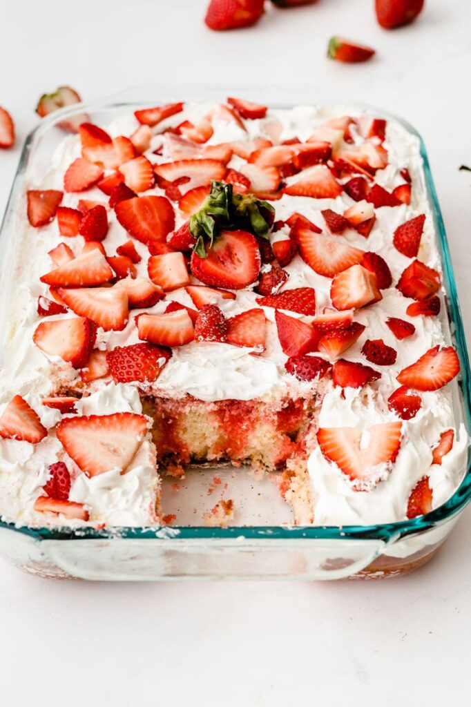 strawberry poke cake with jello in a glass baking dish